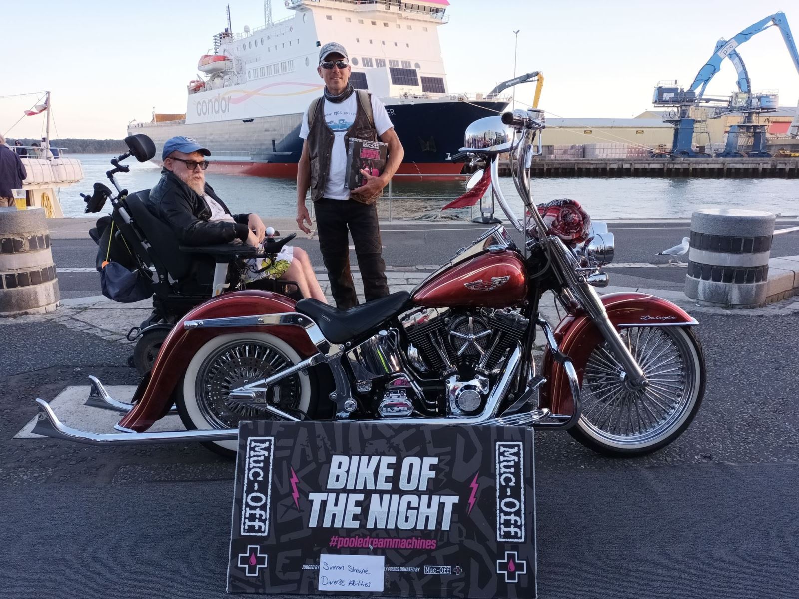 Two men next to the winning bike at Poole Quay